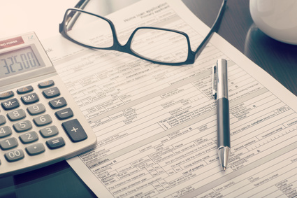 Close up of a bank home loan application form on desk with calculator and eye glasses
